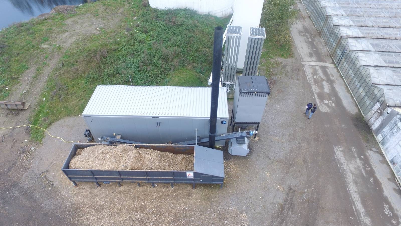 Containerpanncentral med flisficka intill växthus